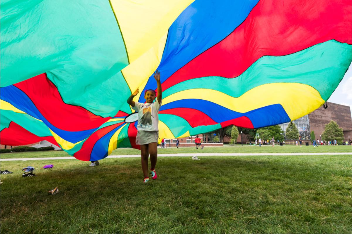 Young child runs under parachute at University of 罗彻斯特